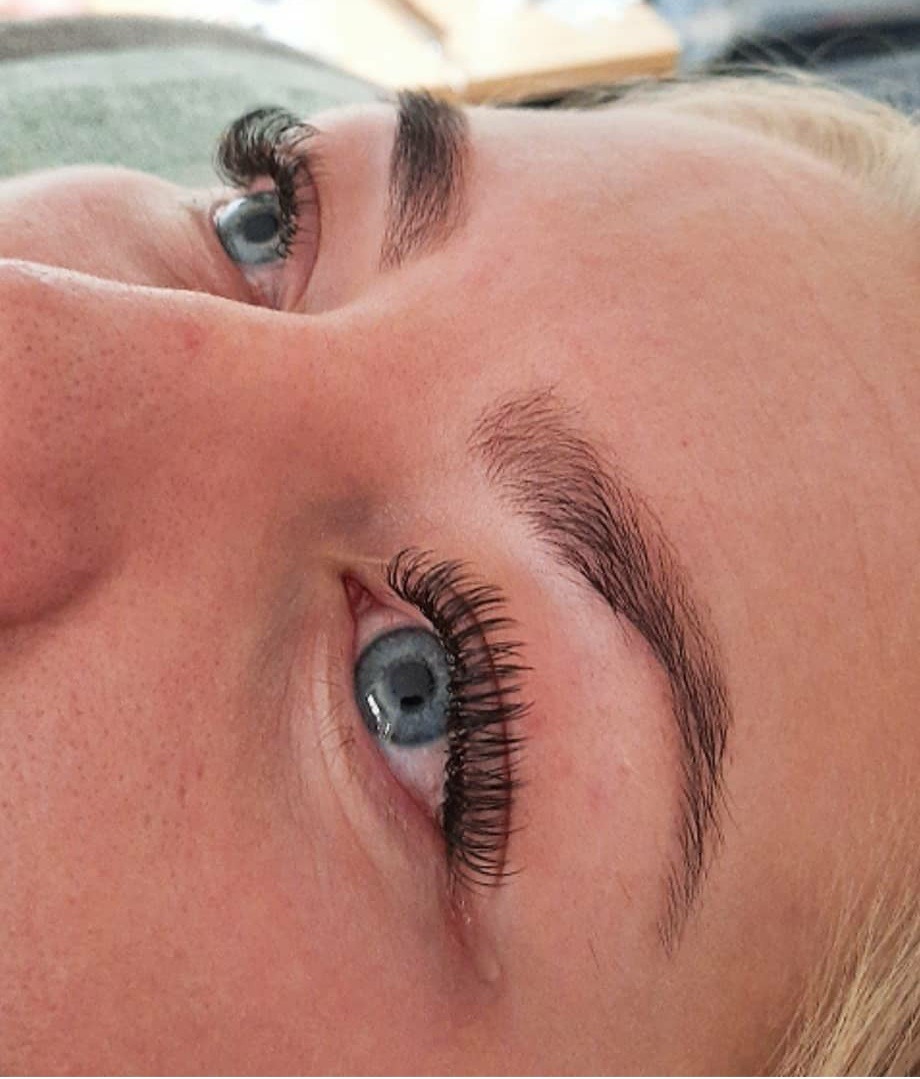 Wimperextensions en een gevulde wenkbrauw bij een klant met blauwe ogen