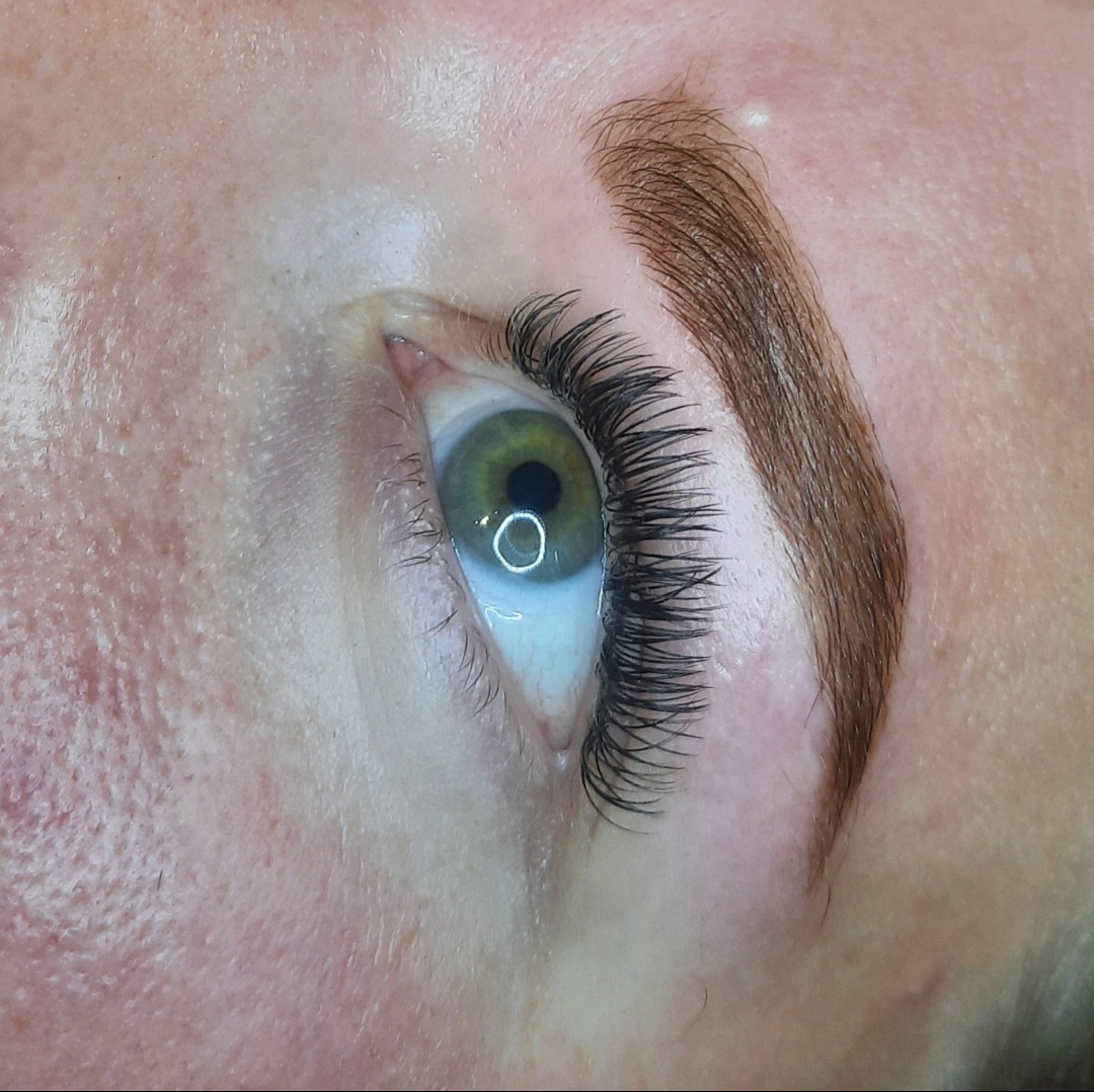 Wimperextensions en een geverfde wenkbrauw in een warme tint